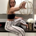 casual spring outfits black tube top and stiped palazzo pants holding gold ball and flowers