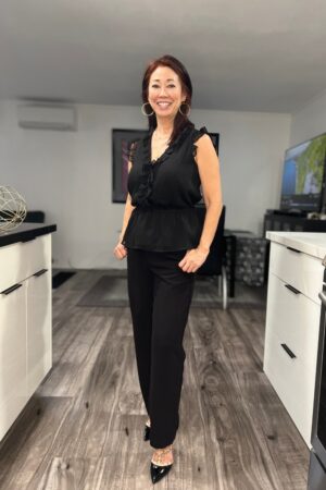 black pants with sleeveless ruffled black top